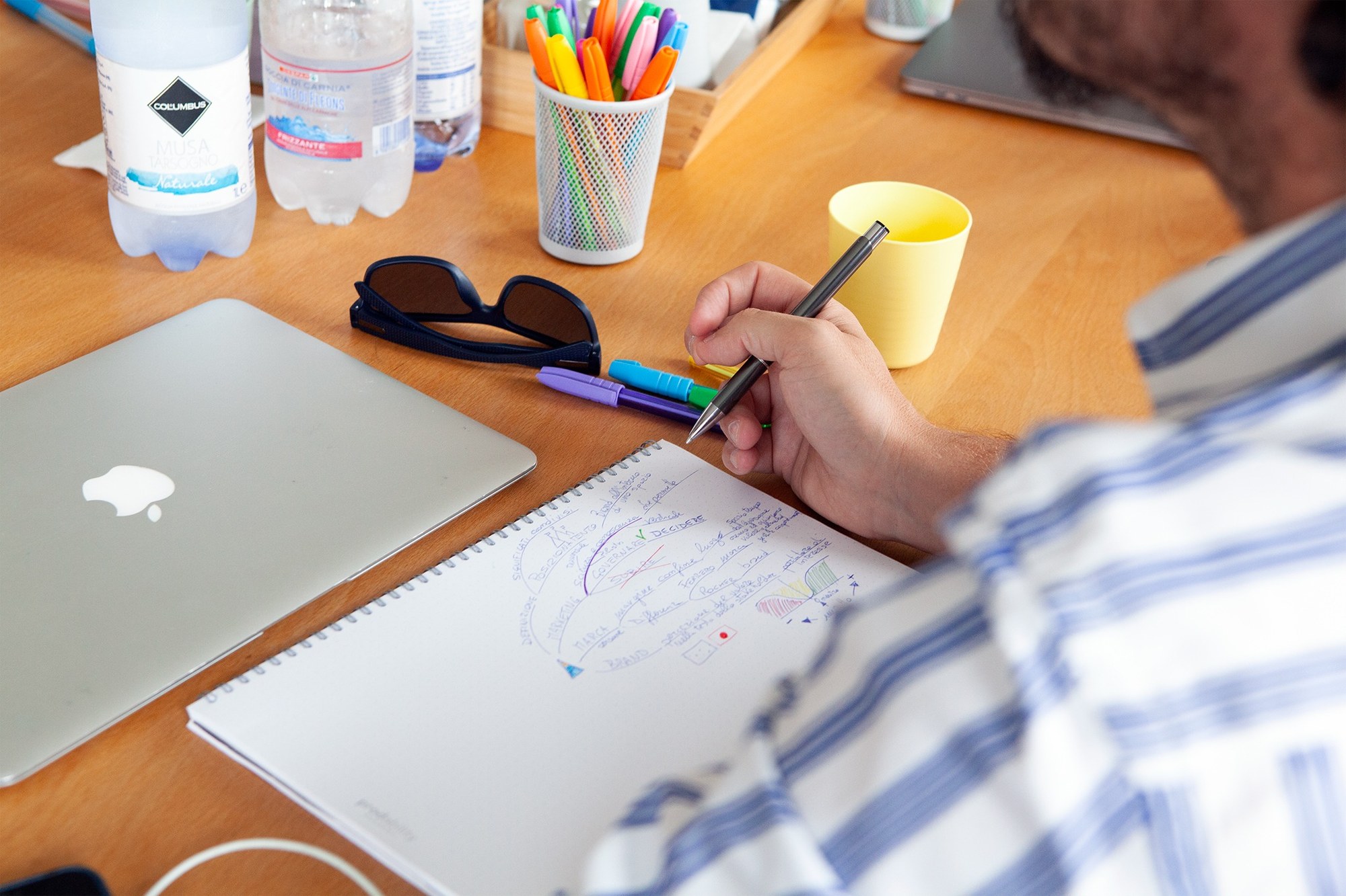 Appunti di lavoro, computer e documentazione usati durante un progetto di brand